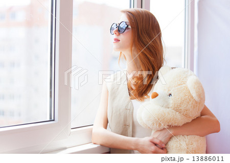Sad grunge girl near window with toy bear Sad grunge girl near window with toy bear 13886011