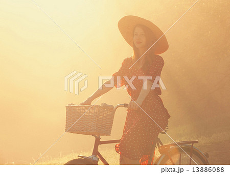 Girl on a bike in the countryside in sunrise time. 13886088