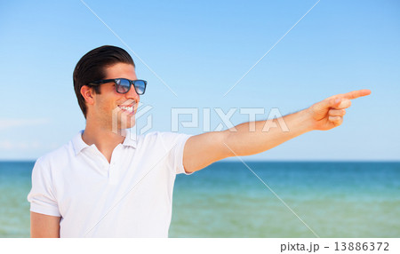 Handsome young man at beach background 13886372