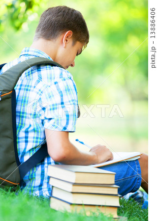 Teen boy with books and notebook at outdoor. Teen boy with books and notebook at outdoor. 13886406