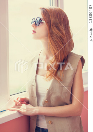 Grunge girl in sunglasses near window 13886407