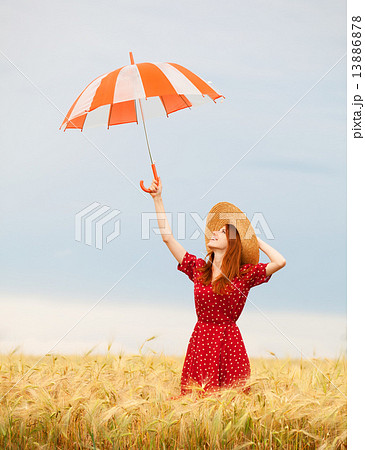 Redhead girl with umbrella at wheat field 13886878