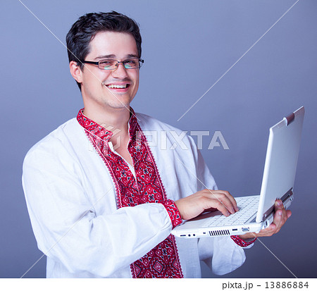 Man in embroidery shirt with laptop Man in embroidery shirt with laptop 13886884