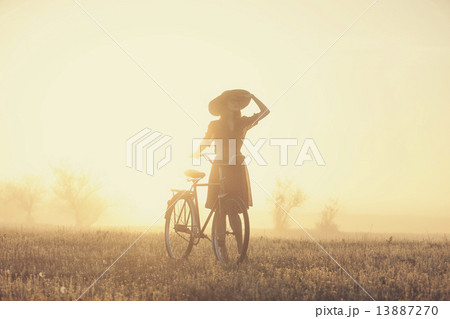 Girl on a bike in the countryside in sunrise time 13887270