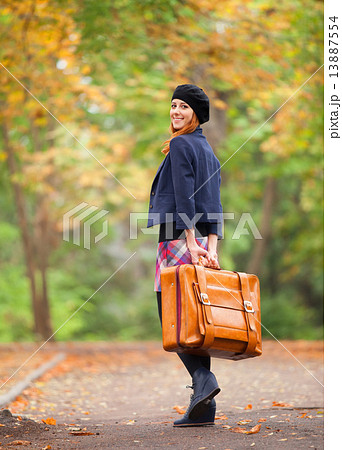 Redhead girl with suitcase at autumn outdoor. 13887554