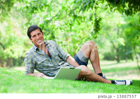 Student with laptop at green grass 13887557