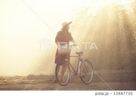 Girl on a bike in the countryside in sunrise time 13887730