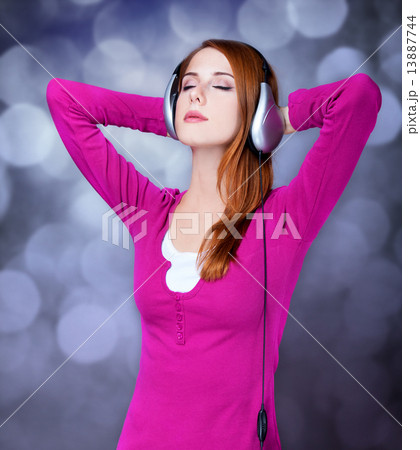 Redhead girl with headphones. 13887744