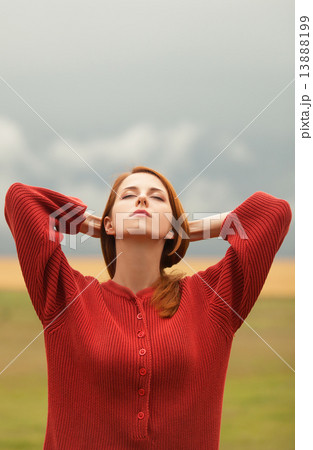 Redhead girl at meadow near wheat field 13888199