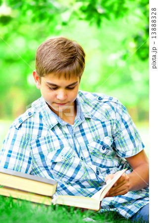 Teen boy with books and notebook in the park. Teen boy with books and notebook in the park. 13888328