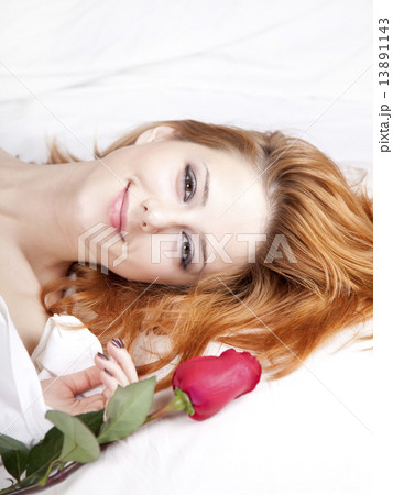 Beautiful red-haired girl with rose in the bed. Beautiful red-haired girl with rose in the bed. 13891143