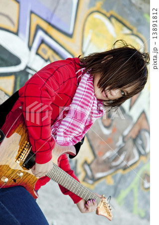 Closeup portrait of a happy young girl with guitar and graffiti Closeup portrait of a happy young girl with guitar and graffiti 13891812