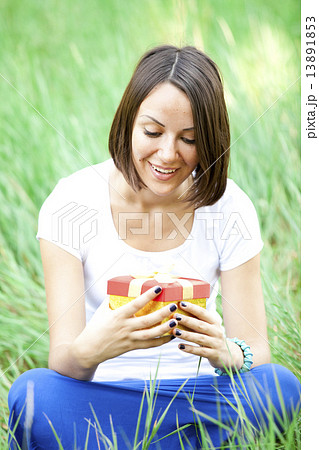 Beautiful teen girl with gift in the park at green grass. Beautiful teen girl with gift in the park at green grass. 13891853