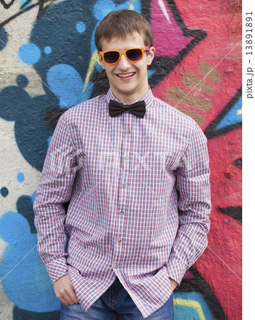 Style teen in glasses standing near graffiti wall. Style teen in glasses standing near graffiti wall. 13891891