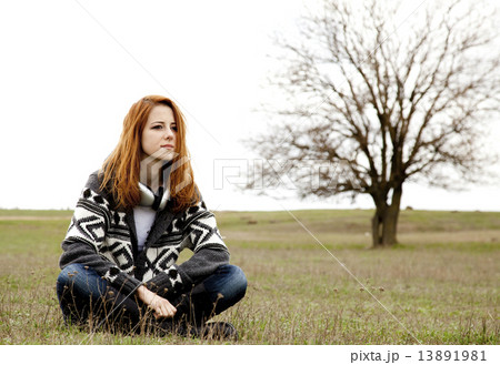 Sad girl with headphones sitting at spring meadow. Sad girl with headphones sitting at spring meadow. 13891981
