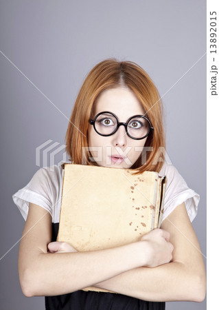 Funny red-haired girl with old book. Funny red-haired girl with old book. 13892015