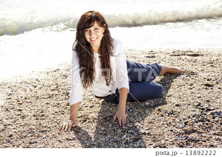 Pretty young woman with sitting on beach 13892222