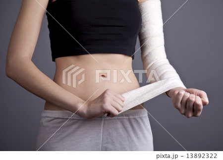 Strong girl's body with with elastic bandage on hand. 13892322