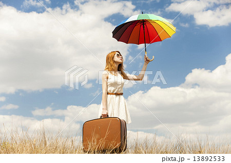 Beautiful redhead girl with umbrella and suitcase at outdoor. Beautiful redhead girl with umbrella and suitcase at outdoor. 13892533