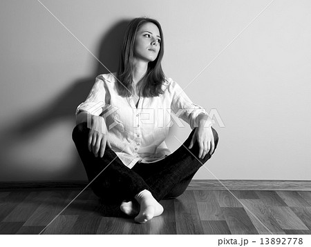 Sad teen girl at floor near wall. Sad teen girl at floor near wall. 13892778