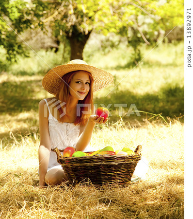 Beautiful redhead girl with fruits in basket at garden. Beautiful redhead girl with fruits in basket at garden. 13892971