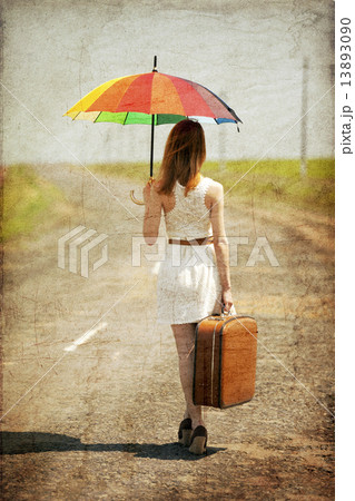Lonely girl with suitcase and umrella at country road. 13893090