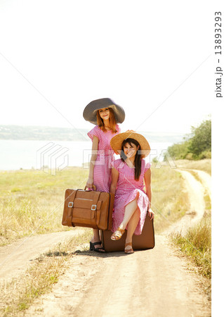 Two retro style girls with suitcases at countryside. 13893293