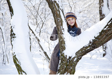 Beautiful young red-haired woman in winter park 13893397