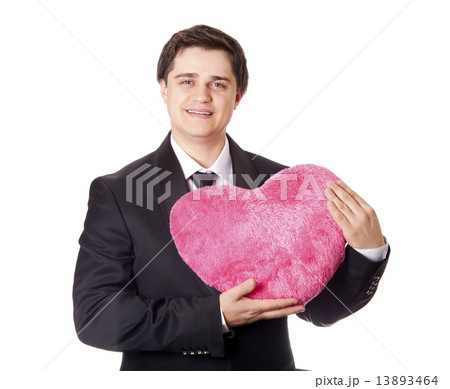 A man holding toy heart in formal black tux with tie isolated on 13893464