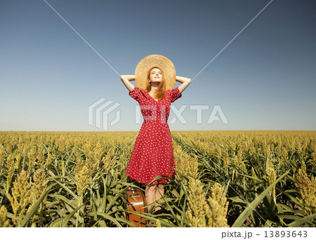 Redhead girl with suitcase at corn field. 13893643