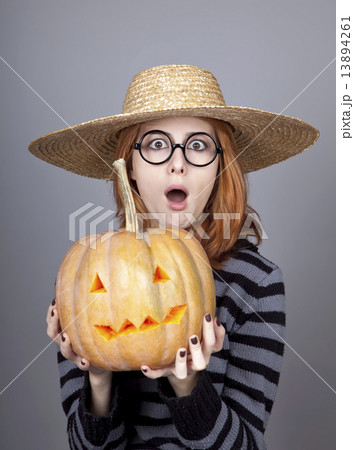 Funny girl in cap showing pumpkin. 13894261