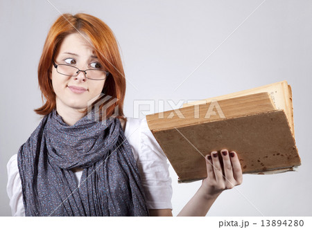 Young doubting fashion girl in glasses with old book 13894280