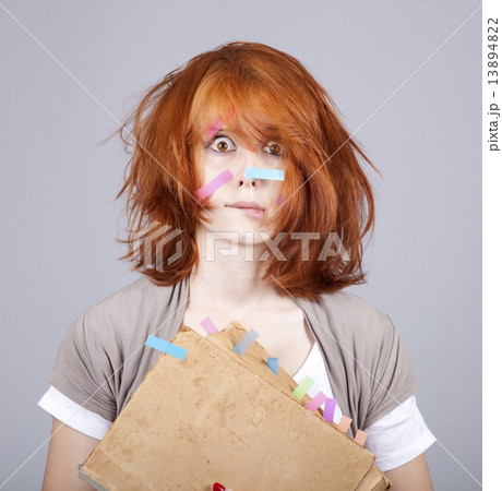 Red-haired businesswoman with book and notes on face. 13894822