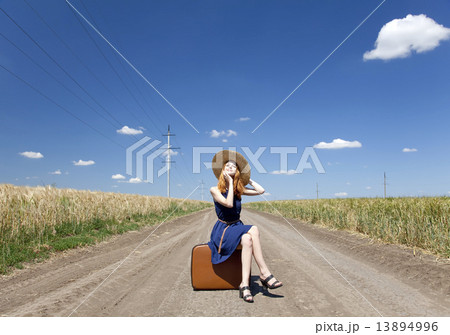 Lonely girl with suitcase at country road. Lonely girl with suitcase at country road. 13894996