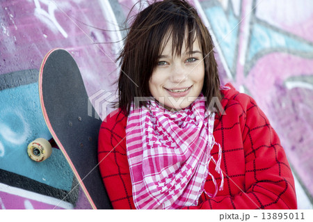 Closeup portrait of a happy young girl with skateboard and graff 13895011