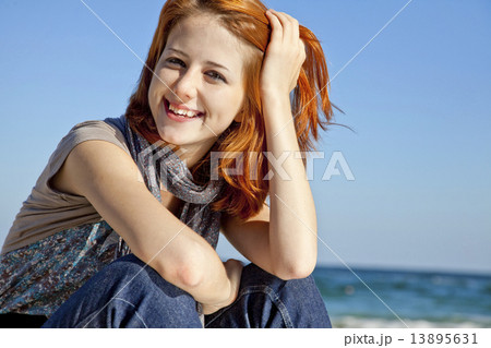Portrait of happy red-haired girl on the beach. 13895631