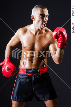 Boxer with red gloves in dark room Boxer with red gloves in dark room 13904126