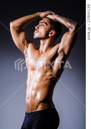 Muscular man in dark studio Muscular man in dark studio 13904138