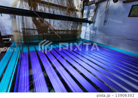 Man weaving silk sari on loom in India 13906302