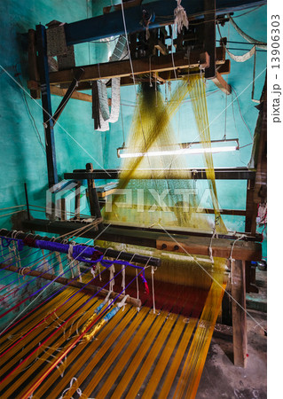 Man weaving silk sari on loom in India 13906303