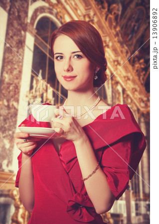 Beautiful redhead women with cup of tea. Photo in old color image style. 13906892