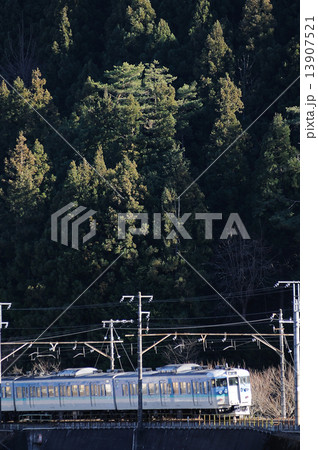 冬の山間を行く中央線の115系ローカル電車 13907521