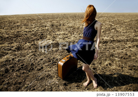 Lonely girl with suitcase at countryside field. 13907553