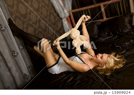 Woman with toy on black silk 13909024