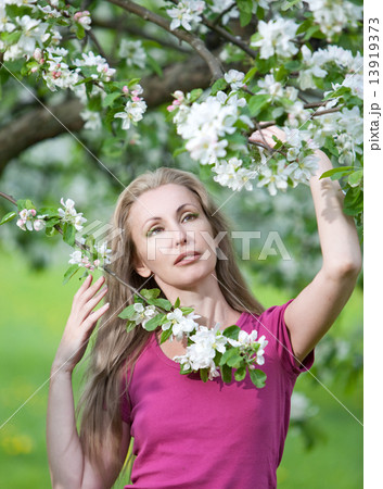 young attractive woman standing near the blossoming apple tree... 13919373