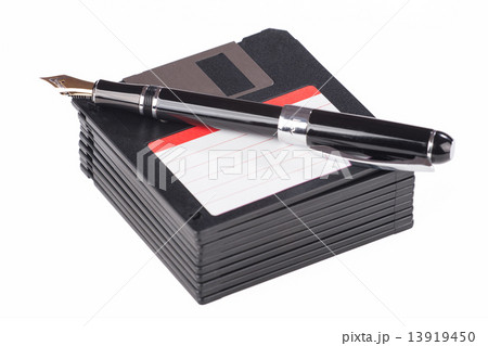 fountain pen lying on a pile of floppy disks 13919450