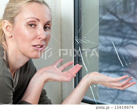 The housewife is upset, the bad quality double-glazed window has burst because of a frost The housewife is upset, the bad quality double-glazed window has burst because of a frost 13919974