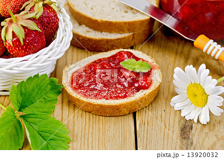 Bread with strawberry jam and chamomile on board 13920032