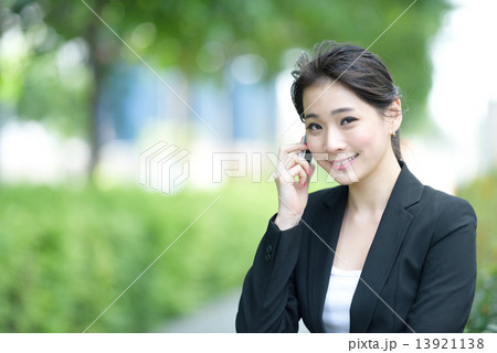 One young successful Chinese businesswoman using mobile phone along promenade 13921138