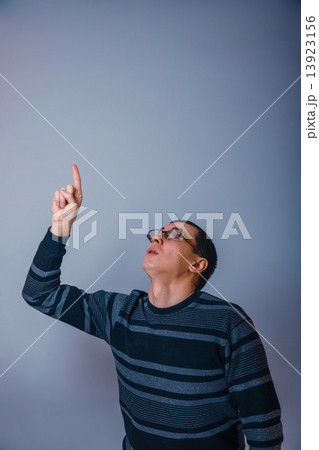 male of European appearance brunet shows his hand up on a gray b 13923156